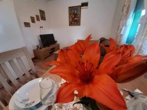 eine große orangefarbene Blume auf einem Tisch in der Unterkunft Ruralna kuća za odmor Viktorija in Čaglin