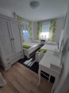 - une chambre avec 2 lits et un bureau dans l'établissement Ruralna kuća za odmor Viktorija, à Čaglin