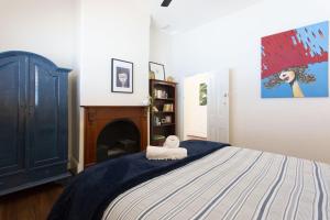 a bedroom with a bed and a painting on the wall at Sweetgum on Lefroy in South Fremantle