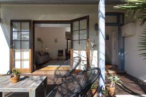 een veranda met 2 stoelen en een houten tafel bij Sweetgum on Lefroy in South Fremantle