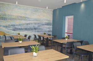 a dining room with tables and chairs and a painting on the wall at MAR60 Apartments in Caorle