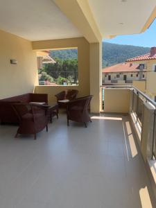 a balcony with chairs and tables and a view at Vergos Hotel in Vourvourou