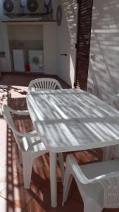 una mesa blanca y sillas en un patio en ANFORA Arancione, en Canneto