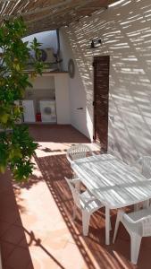 una mesa blanca y sillas en un patio en ANFORA Arancione, en Canneto