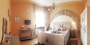 1 dormitorio con 1 cama grande con arco en il Roseto holidays, en Castelnuovo del Garda