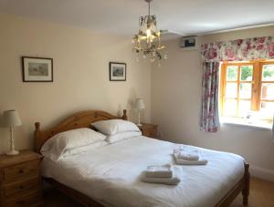 a bedroom with a bed with two towels on it at Elm Tree Cottage in Salton