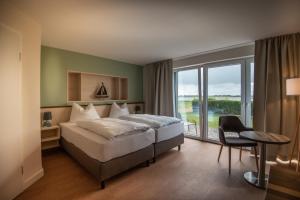 Postel nebo postele na pokoji v ubytování BE BIO Hotel be natural - direkt am Wasser + 37 fotografií