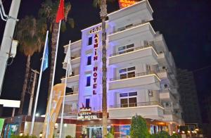 un edificio blanco con un cartel en él por la noche en GARDEN ASMİN OTEl&SPA, en Kızılbağ