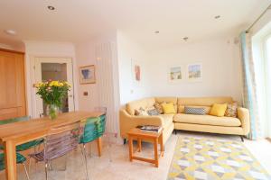 ein Wohnzimmer mit Sofa und Tisch in der Unterkunft Beachside apartment, sea views in Saint Merryn + 18 Fotos
