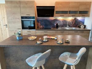 eine Küche mit einer Theke mit Stühlen und Essen darauf in der Unterkunft Berghof Haselsberger Appartements in Sankt Johann in Tirol