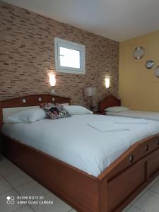 a bedroom with a large bed and a brick wall at House Stella Tasos in Sarti