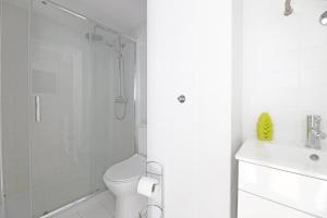ein weißes Bad mit einem WC und einer Dusche in der Unterkunft FLH Porto City Apartment with Balcony in Porto