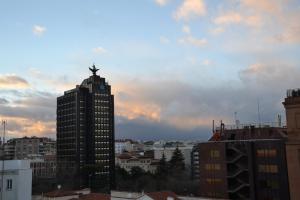 ein hohes Gebäude mit einer Statue oben drauf. in der Unterkunft Hotel Serrano in Madrid
