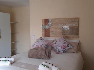 a bedroom with a bed with pillows on it at Aloes Bush Stay in Hoedspruit +7 photos