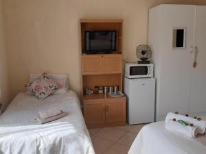 a small room with two beds and a microwave at Aloes Bush Stay in Hoedspruit