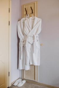 un armario con toallas blancas colgando de una puerta en Ekaterina II Hotel, en Odessa