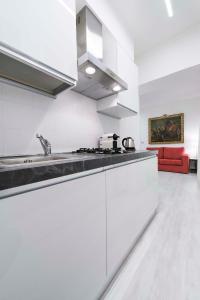 eine Küche mit weißen Schränken und einer roten Couch in der Unterkunft Ca Marta Venice in Venedig