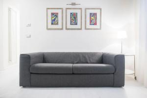 a gray couch in a white room with three paintings at Ca Marta Venice in Venice