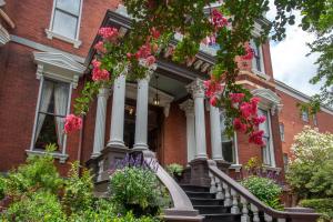 a red brick house with flowers on the stairs at Kehoe House, Historic Inns of Savannah Collection in Savannah