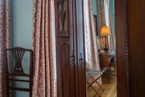 a room with a door and curtains and a lamp at Kehoe House, Historic Inns of Savannah Collection in Savannah