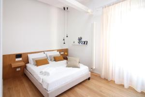 ein weißes Schlafzimmer mit einem großen weißen Bett und einem Fenster in der Unterkunft Pànto - Rooftop boutique rooms in Palermo