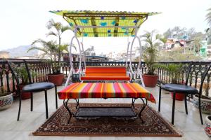 a swing on top of a balcony with palm trees at The LEEF INN 500Ms from Nakki Lake in Mount Ābu