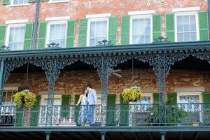 a couple standing on a balcony of a building at The Marshall House, Historic Inns of Savannah Collection in Savannah
