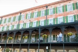 a couple standing on the balcony of a hotel at The Marshall House, Historic Inns of Savannah Collection in Savannah