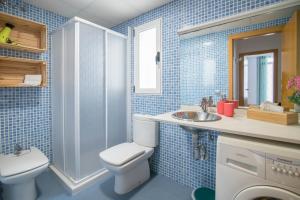 a blue tiled bathroom with a toilet and a sink at Hogar Vera Apartments&Bikes in Valencia