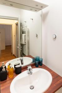een badkamer met een wastafel en een spiegel bij Paysages Normands in Honfleur