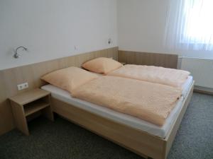 a bed with two pillows on it in a room at Pension Steinle in Erbach