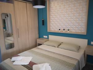 a small bedroom with a bed and a mirror at Gatos House 2 in Pefkohori