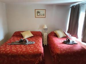 a bedroom with two beds with towels on them at Stansted Lodge Guest House in Elsenham