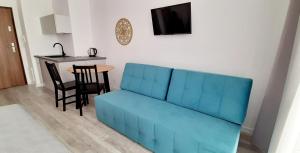 niebieska kanapa w salonie ze stołem w obiekcie Flamingo Apartments w mieście Międzyzdroje
