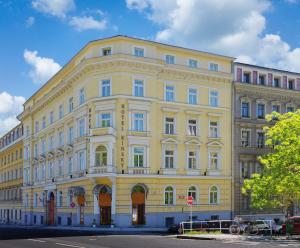 a large yellow building on the corner of a street at Hotel Kinsky Fountain in Prague