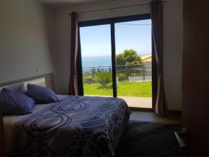 ein Schlafzimmer mit Bett und Blick auf das Meer in der Unterkunft migs'place in Arco da Calheta + 30 Fotos