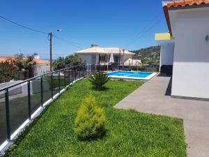 a balcony of a house with a swimming pool at migs'place in Arco da Calheta