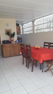 uma sala de jantar com uma mesa vermelha e cadeiras em An ti kaz la em Sainte-Anne