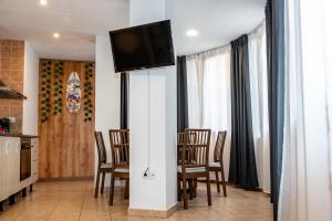 uma sala de jantar com uma mesa e cadeiras e uma televisão em Apartament Central em Lloret de Mar