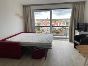 a bedroom with a bed and a large window at Apartment Bel-Air in Knokke-Heist