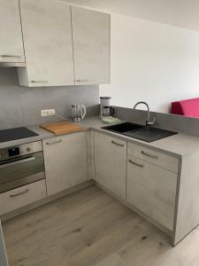 a kitchen with white cabinets and a sink at Apartment Bel-Air in Knokke-Heist