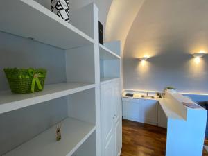Biała kuchnia z białymi półkami i zlewem w obiekcie Suite 261 - intero appartamento nel centro di Bari w mieście Bari