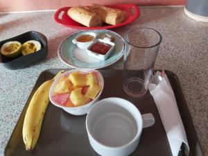 a tray of food with a banana and a cup of coffee at An ti kaz la in Sainte-Anne