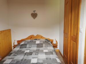 een slaapkamer met een bed met een hartklok aan de muur bij Charmant appartement 6-8 personnes au cœur du village à proximité lac et pistes de ski in Morillon