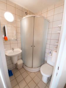 a bathroom with a shower and a toilet and a sink at Pensjonat Bryza in Karwia +22 photos