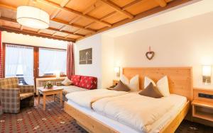 フュッセンにあるシュタイグミューレ ペンション ガルニのベッド2台とソファが備わるホテルルームです。