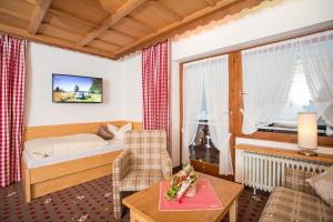 een woonkamer met een bed en een tafel en een kamer bij Steigmühle Pension Garni in Füssen