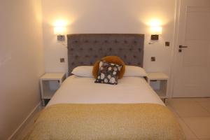 een slaapkamer met een groot bed met 2 nachtkastjes bij Blossom lane in Woodford