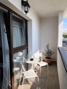 balcón con mesa, sillas y ventana en Sunset apartment, en Bistriţa