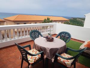 una mesa y sillas en un balcón con vistas al océano en Apartamentos Las Salinas 2, en Caleta de Interián